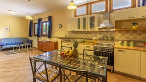 Una cocina compacta con una mesa de comedor, estufa y refrigerador.