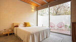 Une chambre à coucher avec un lit, une table de chevet et une vue sur l’extérieur.
