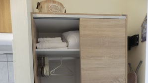 A wooden wardrobe with a hanging shelf and a fold-down desk. - AMZ Apartments (Kato Gouves)