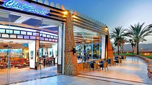 Ein Restaurant mit Glasfassade, Außenbereich und einer Steinsäule.