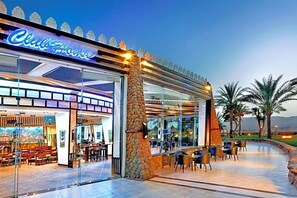 Ein Restaurant mit Glasfassade, Außenbereich und einer Steinsäule.