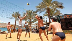 A beach volleyball game with players in swimwear, palm trees, and a beachside setting. - Albatros Sharm Resort By Pickalbatros (Sharm El Sheikh)