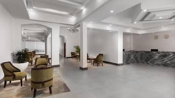 A spacious lobby with a reception desk, seating area, and a chandelier.