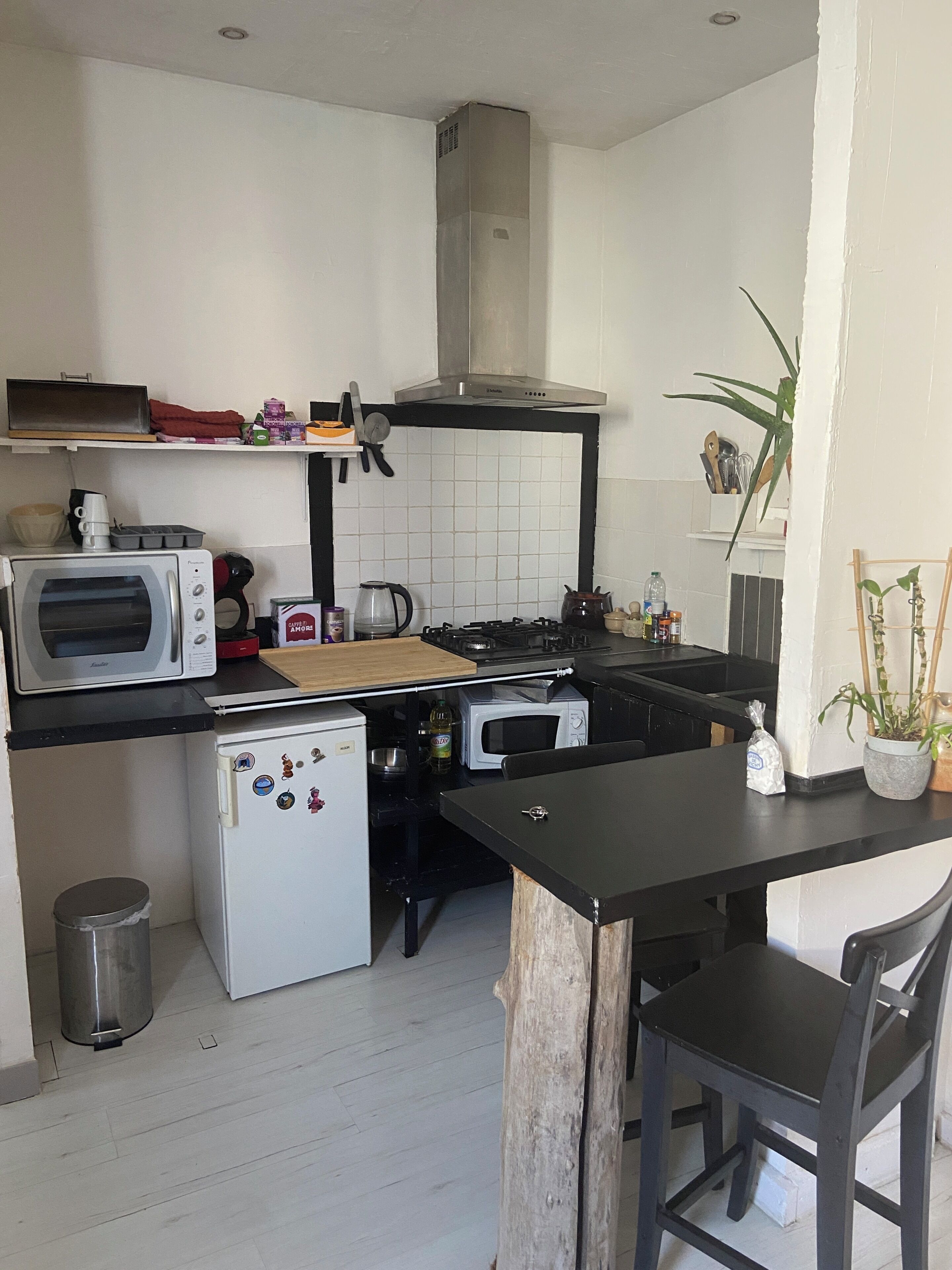 Eine kleine Küche mit Mikrowelle, Herd und Kühlschrank.