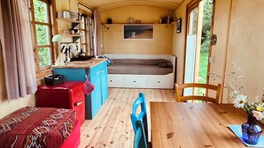 A compact, well-lit room with a kitchenette, a bed, and a dining area. - Beautiful circus wagon in a secluded location  (Oetzen)