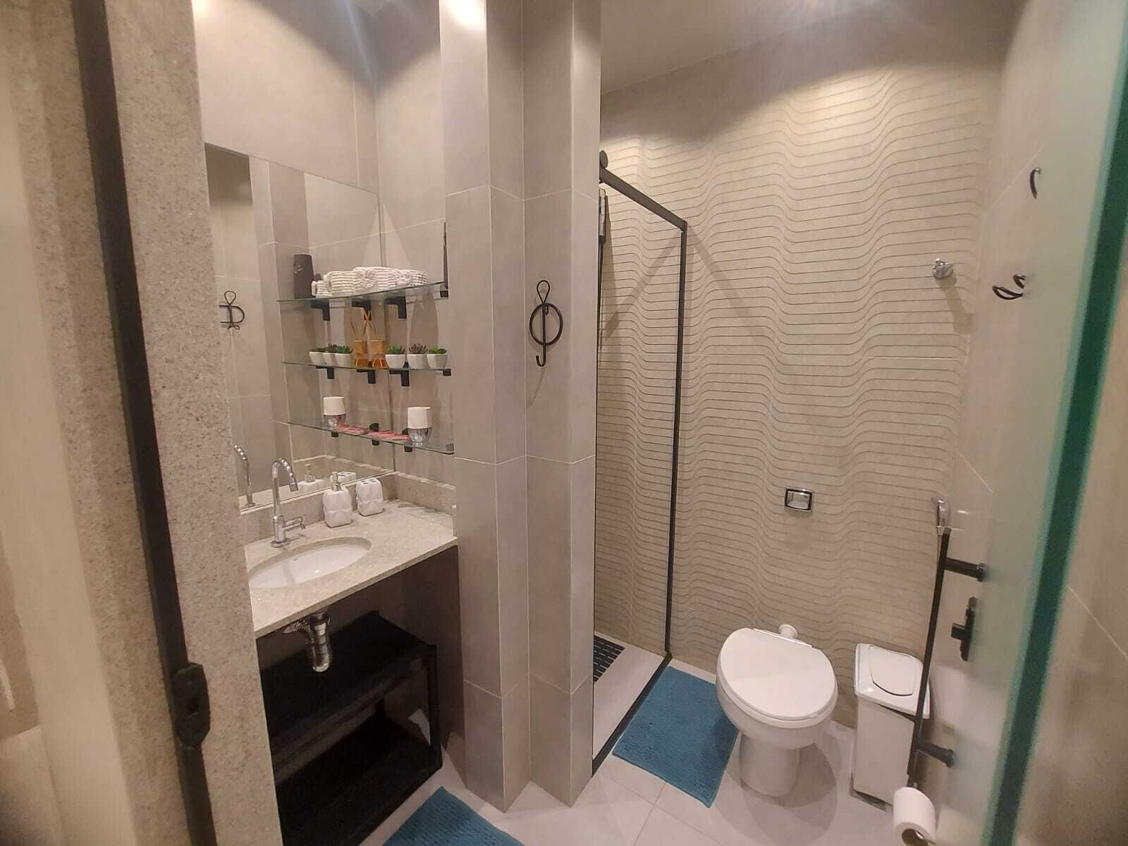 Une petite salle de bain comprenant une douche, des toilettes et un lavabo.