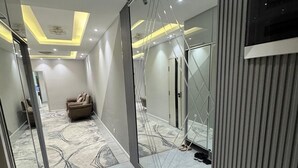 En modern hall med en stor spegel, en soffa och en mönstrad matta.