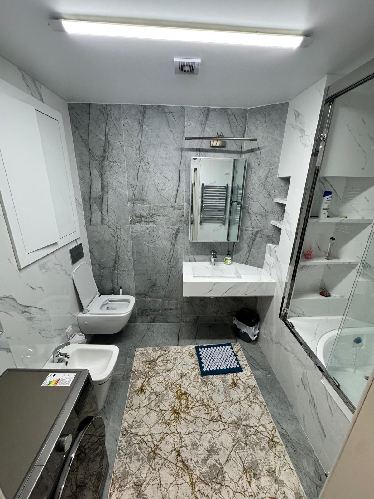 Un baño moderno con inodoro, lavamanos y bañera.