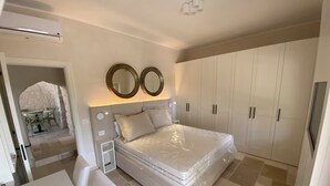 Une chambre à coucher avec un grand lit, une armoire et une petite table avec des chaises.