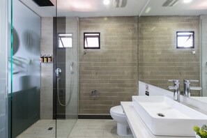 Une salle de bain moderne avec une douche à parois de verre, un lavabo blanc et des toilettes.