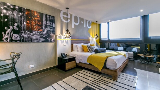Une chambre à coucher moderne avec un grand lit, un bureau et une chaise.
