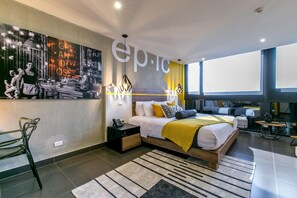 A modern bedroom with a large bed, a desk, and a chair. - Epic Boutique Hotel (Medellín)