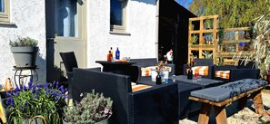 An outdoor seating area with wicker furniture, a table with drinks, and potted plants. - Case Belvene Regio Spa, Theux (Theux)