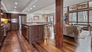 A spacious kitchen with a central island, wooden flooring, and modern appliances. - Stonebridge  (Park City)