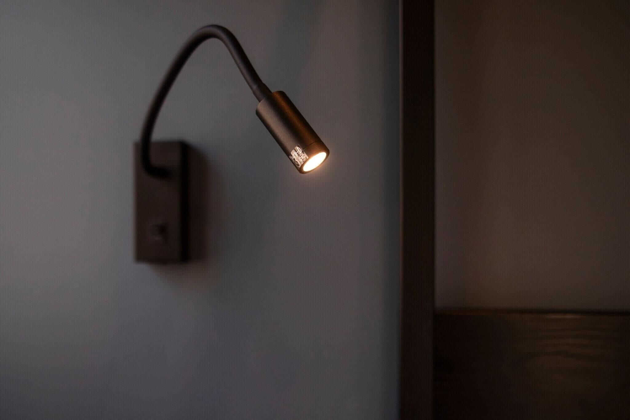 Eine Wandleuchte mit geschwungenem Design und einem sichtbaren Schalter.