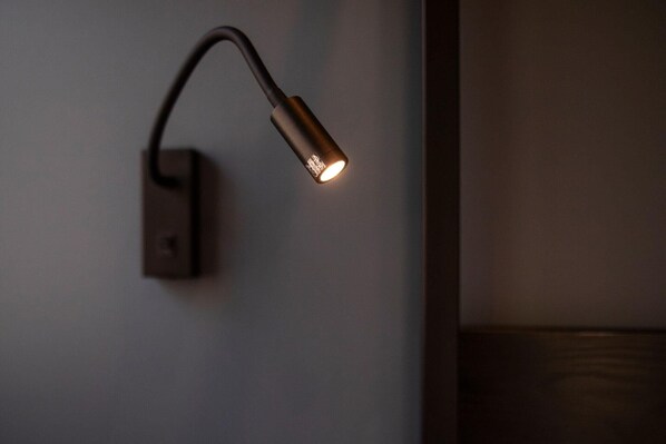 A wall-mounted light fixture with a curved design and a visible switch.