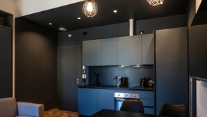Una cocina moderna con comedor, que incluye un sofá, una mesa y una cafetera.