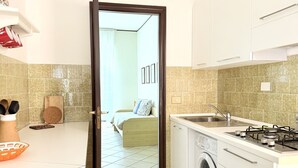 A compact kitchen with a washing machine, a sink, and a stove. - M434 – Marcelli, three-Room Apartment in Residence with Pool (Marcelli)