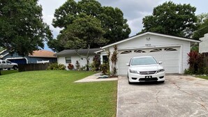 A residential garage with a white car parked in front.