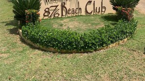 A sign welcoming to 87% Beach Club, surrounded by well-maintained landscaping and palm trees. - Luxury 3BR Villa I Private Pool I Wi-Fi I 30 Minutes from Montego Bay Airport! (Coral Spring)