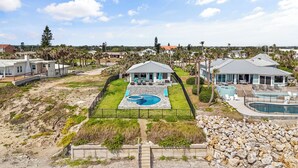 Una propiedad residencial con piscina, un patio cubierto y vistas del barrio.