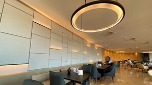 A modern dining area with a long counter, cushioned seating, and a circular light fixture. - Hotel Nacional (Rio de Janeiro)
