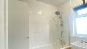A bathroom with a bathtub, a shower, and a sink.