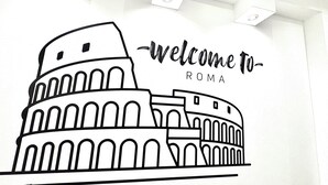 Un dibujo lineal del Coliseo con el texto 'welcome to ROMA' encima.