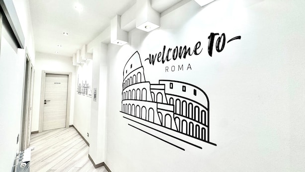 Un pasillo con un mural que muestra el Coliseo y el texto 'welcome to ROMA'.