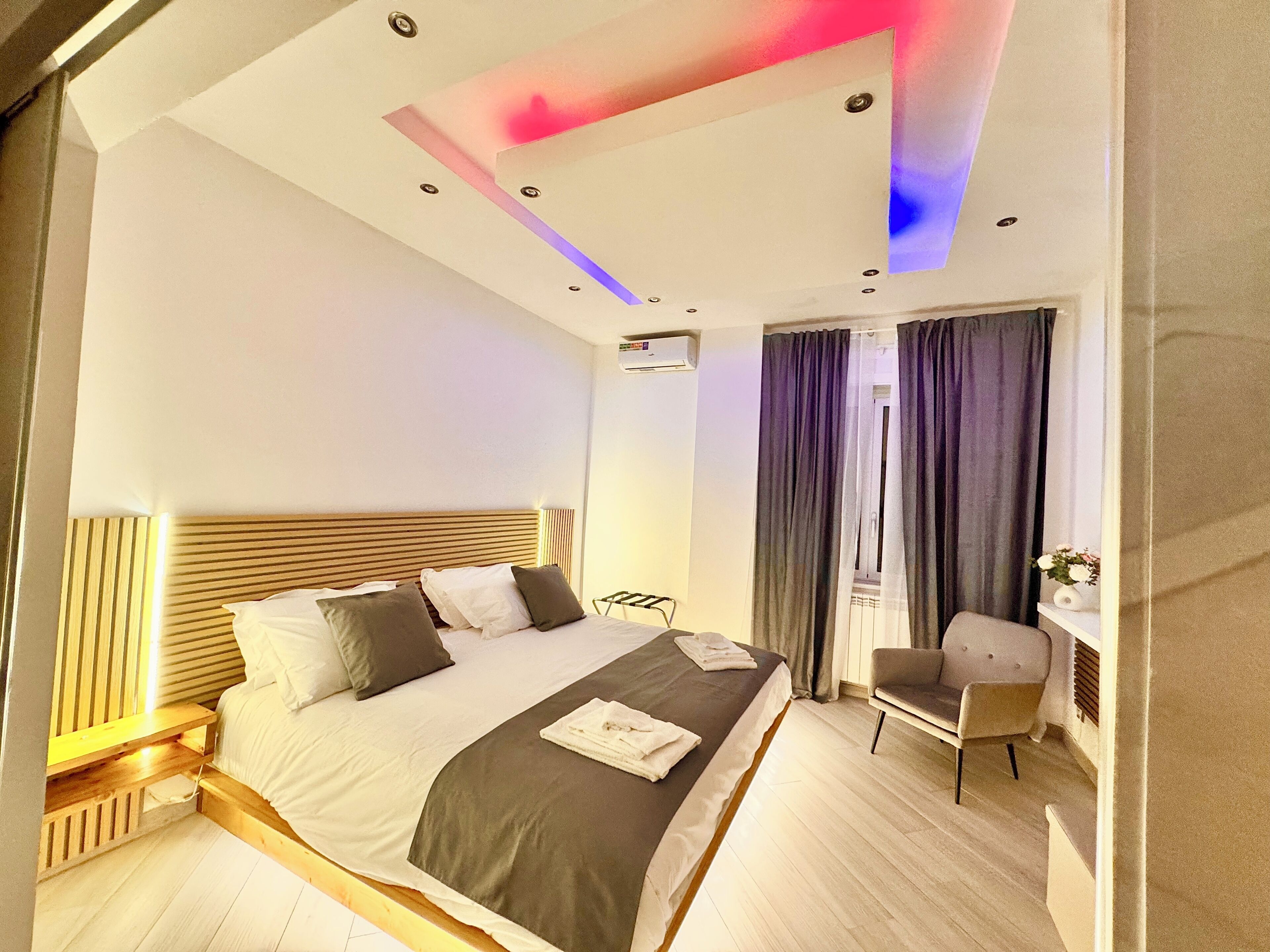 Une chambre d’hôtel moderne, dotée d’un grand lit, d’un bureau et d’une chaise.