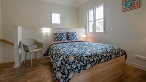 A bedroom with a bed, a chair, a window, and a painting on the wall. - Number 1 - MORVILLIERS (MORVILLIERS)