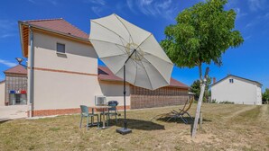A building with a red-tiled roof, a white exterior, and a large umbrella in the foreground. - Number 1 - MORVILLIERS (MORVILLIERS)
