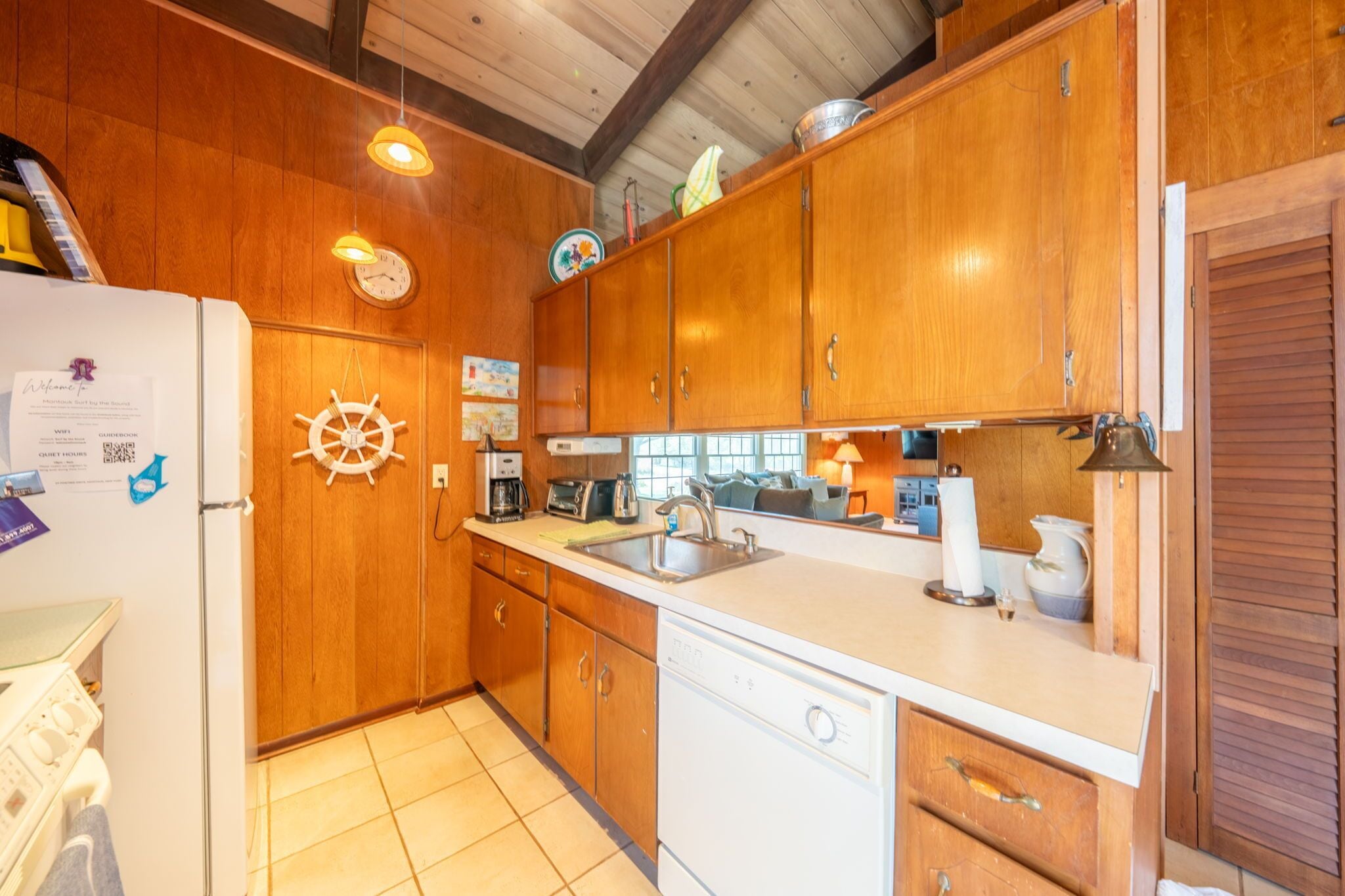 A kitchen with wooden cabinets, a dishwasher, a sink, and a stove.