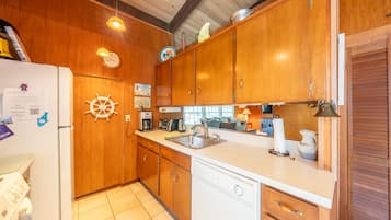 A kitchen with wooden cabinets, a dishwasher, a sink, and a stove.