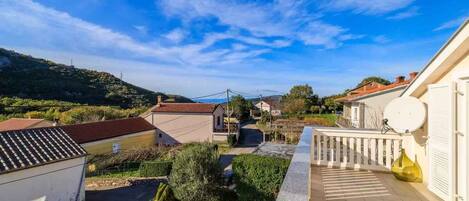 A residential area with a house featuring a balcony with a view of the surrounding landscape.