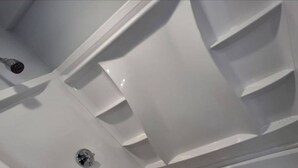 Un gros plan d’une surface blanche, lisse et brillante, sur laquelle se trouvent un objet métallique et un boulon.