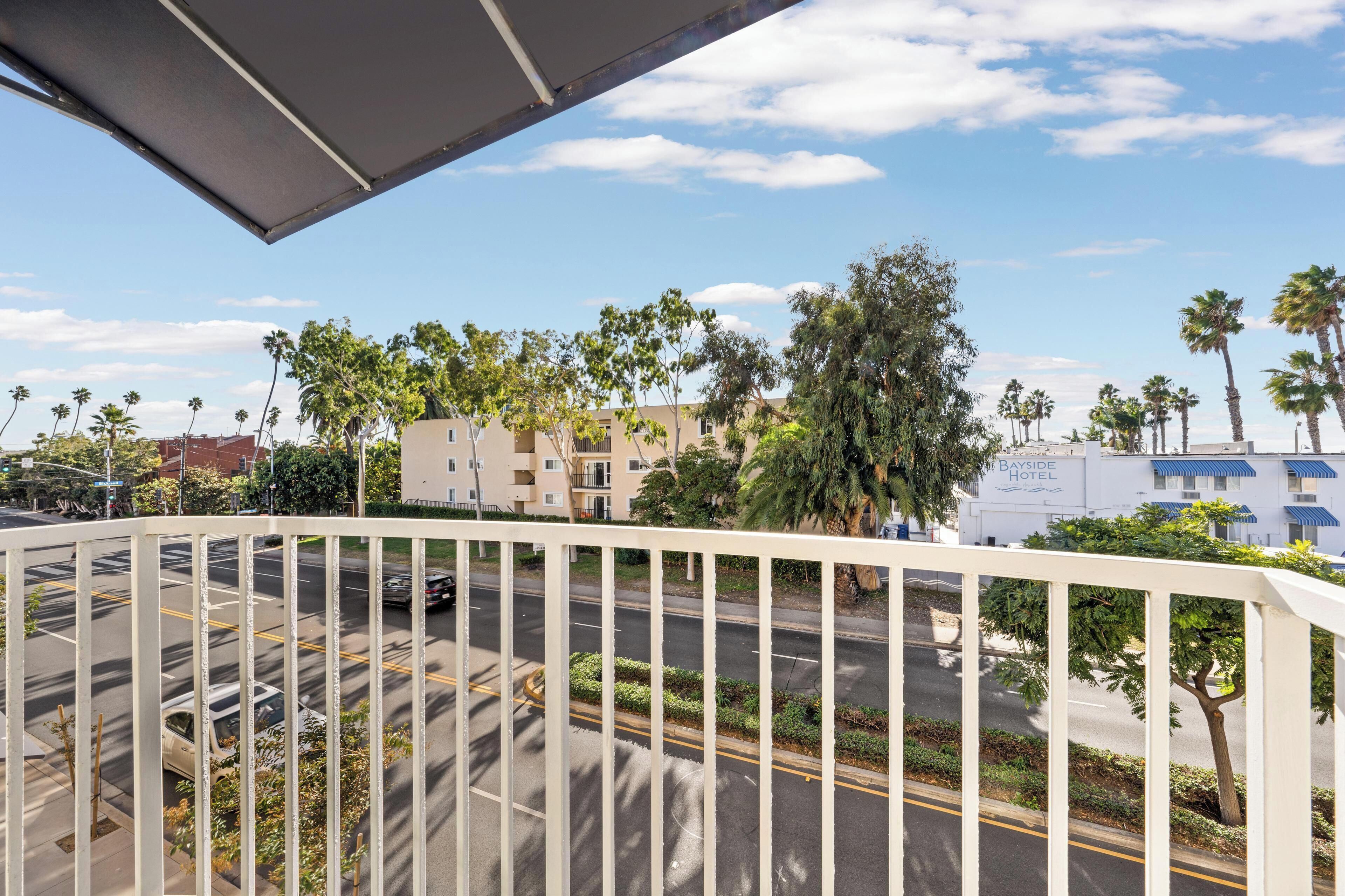 A hotel with a view of a road, palm trees, and a building labeled "Bayside Hotel".