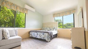 A bedroom with a bed, a sofa, and a cabinet. - Villa Campiña Family Home Scenic Mountain Views (Utuado)