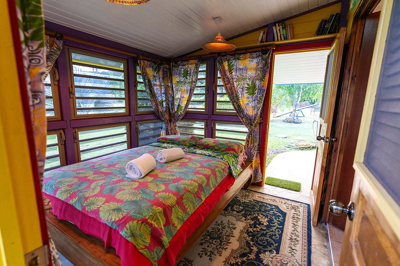 Un dormitorio con una cama grande, cortinas y vistas al exterior.