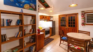 Una cocina compacta con armarios de madera, un refrigerador y un comedor con mesa y sillas.
