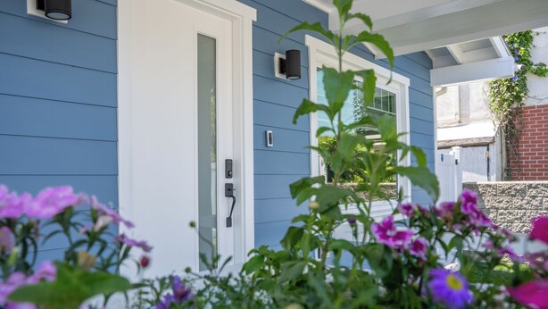 A house with a blue exterior, a white door, and a small porch area.