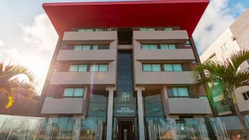 Un moderno edificio de hotel con techo plano, varios balcones y un cartel que indica que es un hotel.