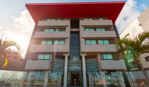 Un hôtel moderne, avec un bâtiment à toit plat, de nombreux balcons et une enseigne indiquant qu’il s’agit d’un hôtel.