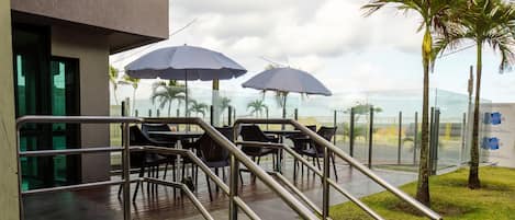 A swimming pool area with steps leading into the water, outdoor seating, and umbrellas.