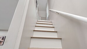A staircase with white walls and wooden steps.