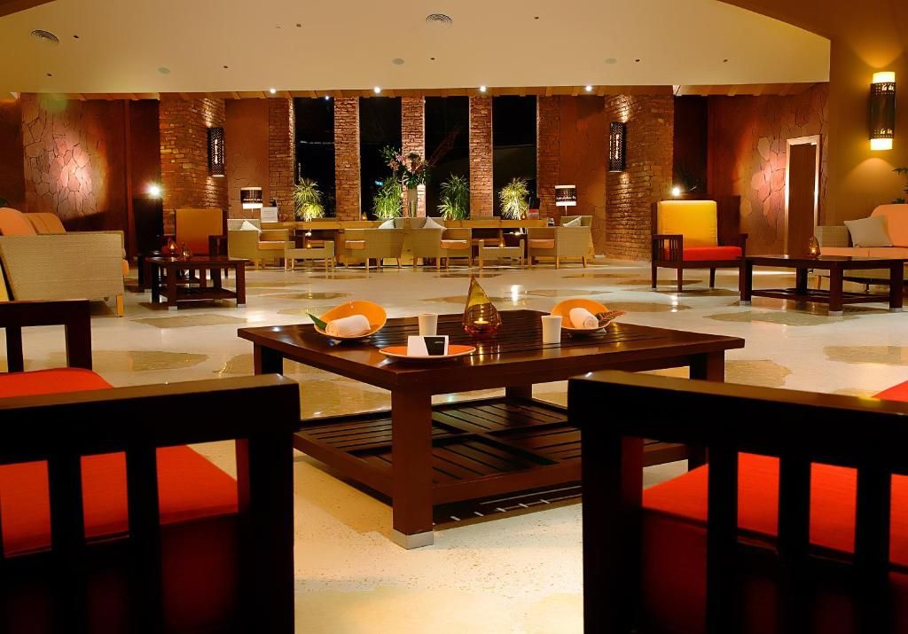 A lobby with a reception desk, seating area, and a decorative centerpiece on the table.