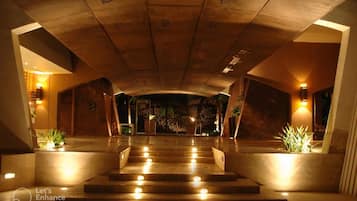 A hotel lobby with a grand staircase, warm lighting, and a modern design.