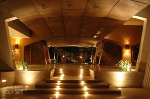 A hotel lobby with a grand staircase, warm lighting, and a modern design.