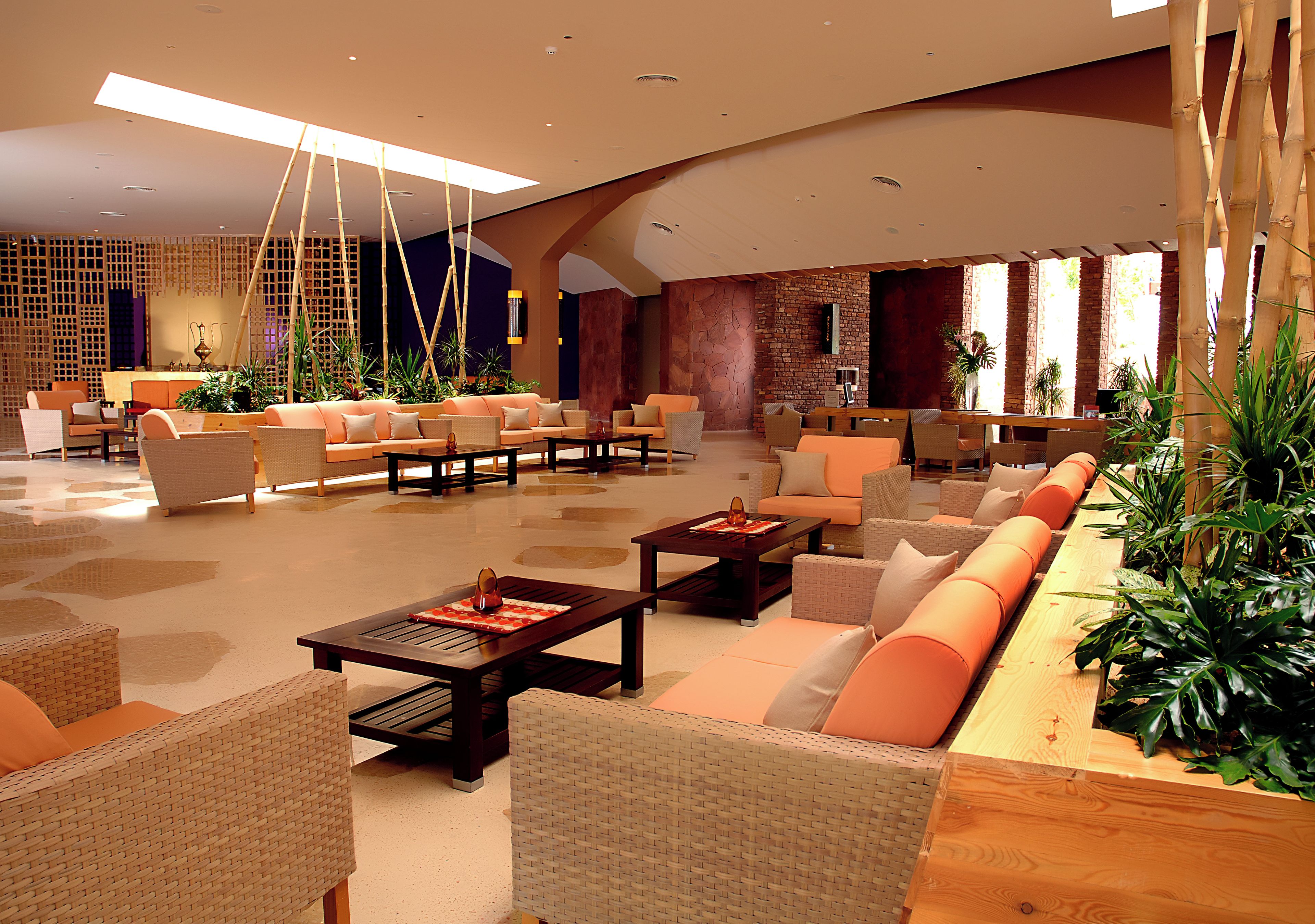 Un vestíbulo amplio con varias zonas de estar, incluyendo sofás y sillones, distribuidos alrededor de mesitas de café.