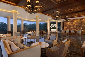 Un vestíbulo espacioso con techos altos, candelabros ornamentales y una amplia decoración mural.
